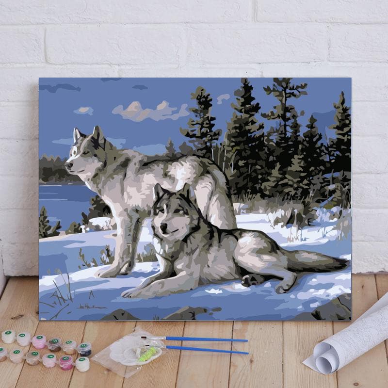 Two wolves laying on the snow